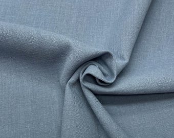 May include: A close-up of a soft, blue fabric with a textured weave. The fabric is folded and draped, showing its texture and colour.