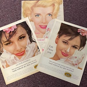 May include: Three vintage magazine advertisements for Lux soap. Each ad features a woman with a close-up of her face, washing with Lux soap. The text on the ads reads "Lux - You're Wonderful!" and "Your moisturizing creamy lather lets me wash without dry skin worries!"