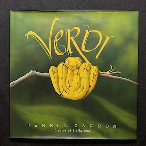 May include: A children's book cover with the title "Verdi" in yellow script. A yellow snake is coiled on a branch against a green background. The author's name, Janell Cannon, is printed below the title, with "Creator of Stellaluna" below her name.