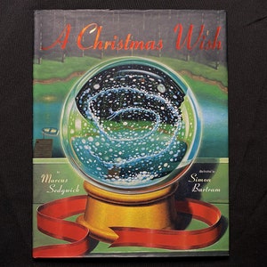 May include: A book cover with a red ribbon and a snow globe with a swirling blue and white design. The title of the book is "A Christmas Wish" by Marcus Sedgwick and illustrated by Simon Bartram.