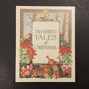 May include: A book cover with a green, red, and white border. The title is "Treasured Tales of Christmas". The cover features a winter scene with a toy soldier, a toy drum, a toy wagon, and a toy doll.
