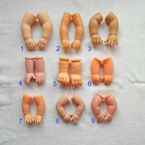 Può includere: Nove paia di braccia di bambola in varie tonalità di pelle. Le braccia sono di plastica e sono in posizioni diverse, con alcune mani aperte e altre chiuse. Le braccia sono numerate da 1 a 9.