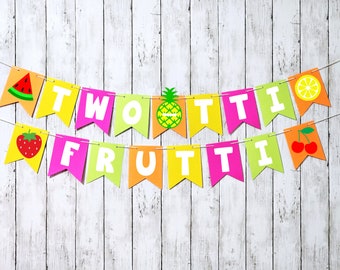 May include: A colorful banner with the words "Two Tutti Frutti" in white letters on a yellow, orange, green, and pink background. The banner is decorated with images of a watermelon, strawberry, pineapple, lemon, and cherries.