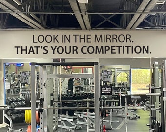 Peut inclure: Une salle de sport avec un miroir et une citation motivante sur le mur qui dit "Regardez-vous dans le miroir. C'est votre compétition."