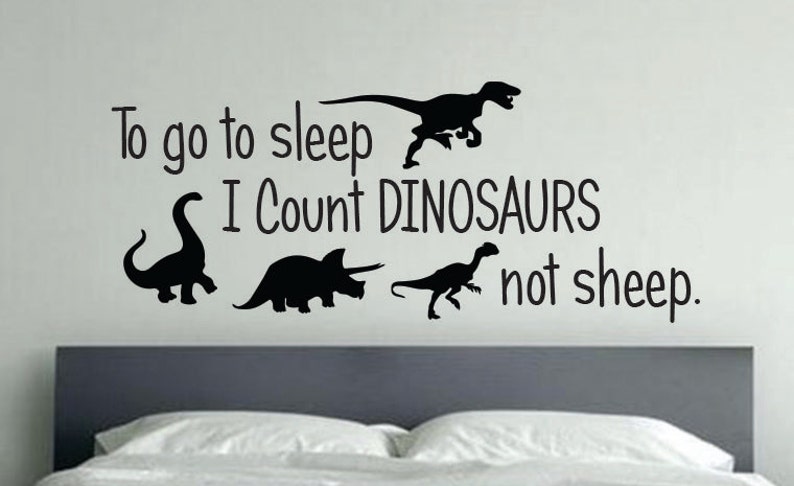 May include: Black and white wall decal with the text "To go to sleep I count DINOSAURS not sheep."  The decal features four silhouettes of dinosaurs.