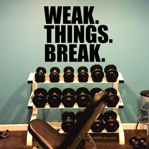 May include: A home gym with a weight rack, a weight bench, and a stool. The wall has a motivational quote that reads "WEAK. THINGS. BREAK."