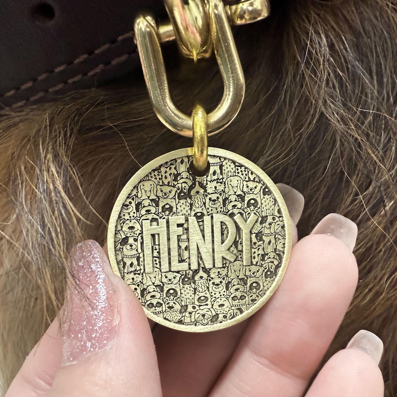 Puede incluir: Chapa de perro de lat&oacute;n con un dise&ntilde;o de muchos perros y el nombre "HENRY" grabado en ella.