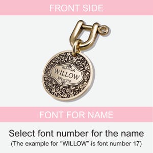 May include: Gold-toned metal pet tag with an ornate design and the word "WILLOW" engraved in a black font. The tag is attached to a gold-toned metal ring.