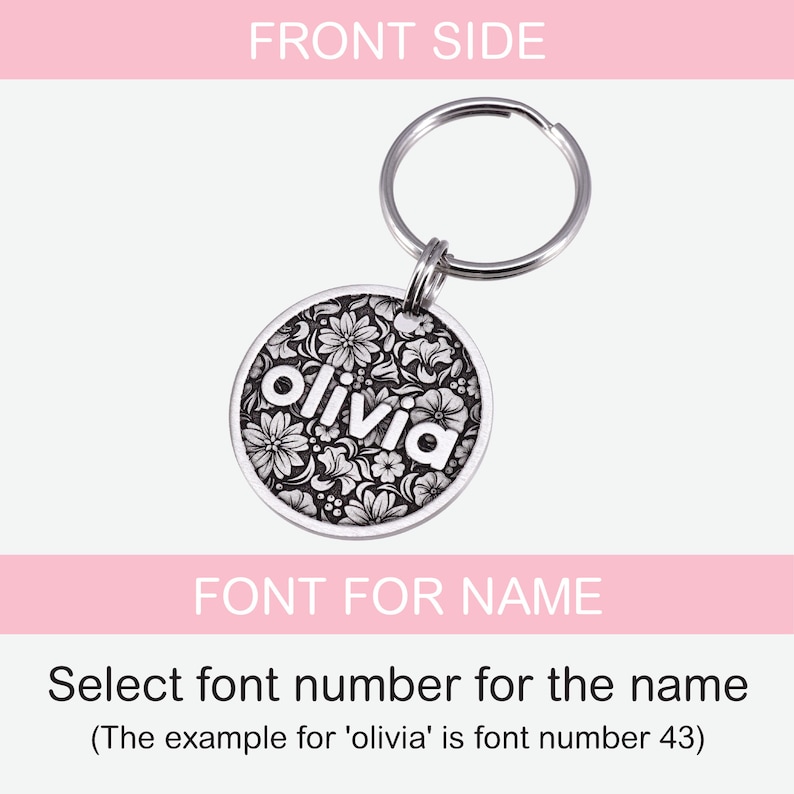 Puede incluir: Llavero de plata con una etiqueta redonda con un dise&ntilde;o floral y el nombre "olivia" en letras blancas. La etiqueta est&aacute; unida a un llavero de plata.