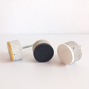 Peut inclure: Trois poign&eacute;es de tiroir en b&eacute;ton avec des accents de couleurs diff&eacute;rentes. La premi&egrave;re poign&eacute;e a un accent jaune, la deuxi&egrave;me un accent noir et la troisi&egrave;me un accent blanc.