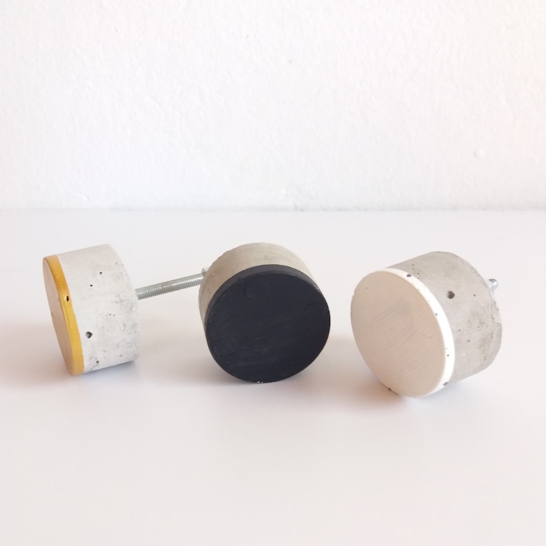 Peut inclure: Trois poign&eacute;es de tiroir en b&eacute;ton avec des accents de couleurs diff&eacute;rentes. La premi&egrave;re poign&eacute;e a un accent jaune, la deuxi&egrave;me un accent noir et la troisi&egrave;me un accent blanc.