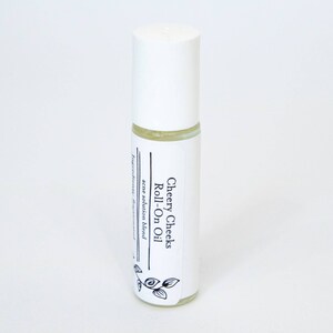May include: A white roll-on bottle with a label that reads "Cheery Cheeks Roll-On Oil" and "acne solution blend".