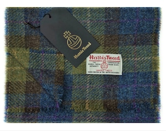 May include: A green, blue, and purple plaid Harris Tweed scarf with a brown leather tag that says "Harris Tweed" and has a logo of a globe with a cross on top.