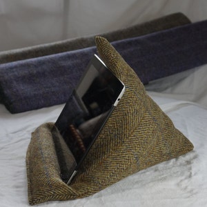 May include: A brown and yellow tweed pillow with a herringbone pattern, designed to hold a tablet or book at an angle for comfortable viewing.