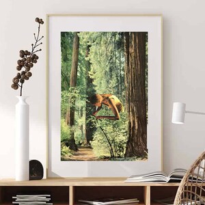 May include: A framed art print featuring a surreal image of a person suspended in a forest. The artwork has a vintage aesthetic, with a color palette dominated by greens and browns. The print is displayed above a wooden cabinet with woven door panels.