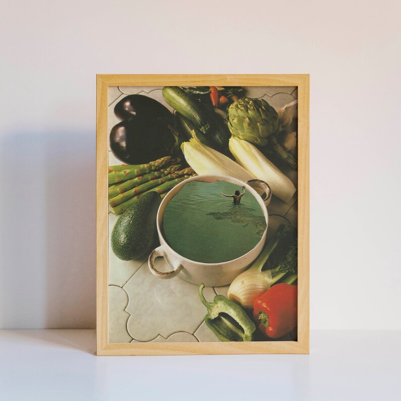 May include: A white ceramic bowl filled with green liquid, surrounded by various vegetables, including asparagus, aubergine, avocado, and a spring onion. The bowl is on a tiled surface.