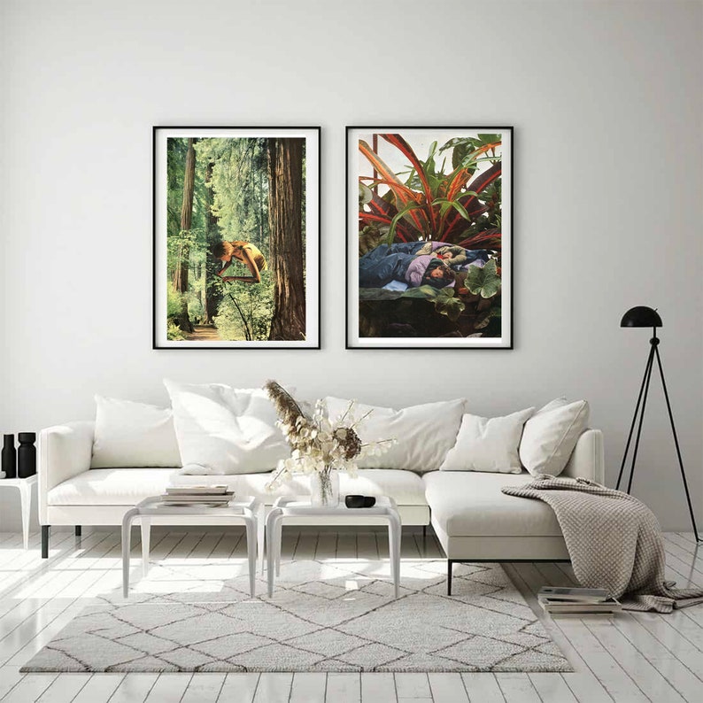 May include: Two framed art prints. The left print depicts a person in a forest, the right print shows a person among plants. The prints are displayed above a white sofa with white tables and a patterned rug. A black floor lamp is in the background.