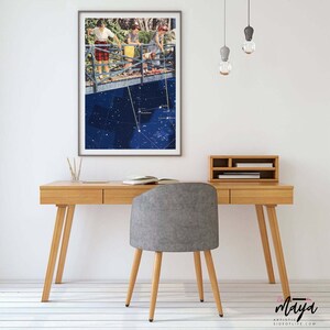 May include: A framed collage art print featuring three women standing on a bridge, with a constellation map in the background. The bridge is suspended over a dark blue sky with white stars.