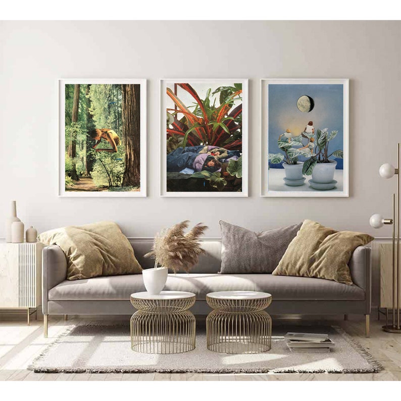 May include: Three framed art prints with white borders hang above a gray sofa. The prints feature surreal collages: a forest scene, a person sleeping among plants, and a moonlit scene with potted plants.