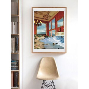 May include: A framed print of a surrealist collage depicting a red room with gold-framed windows that open onto a beach scene with crashing waves.