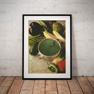 May include: A white ceramic bowl filled with green liquid, resembling a swimming pool, with a person swimming in the centre. The bowl is surrounded by various vegetables, including asparagus, avocado, eggplant, and green onions, on a tiled surface.