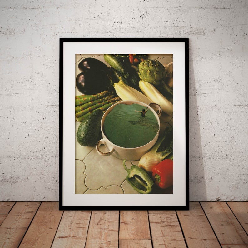 May include: A white ceramic bowl filled with green liquid, resembling a swimming pool, with a person swimming in the centre. The bowl is surrounded by various vegetables, including asparagus, avocado, eggplant, and green onions, on a tiled surface.
