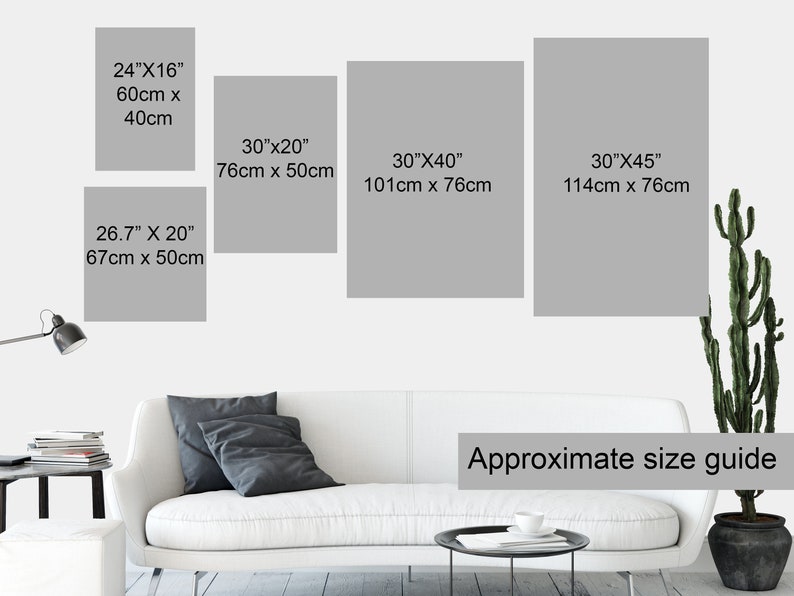 May include: Approximate size guide for framed art prints. The guide shows four different sizes of prints, with measurements in inches and centimeters. The prints are displayed on a white wall above a white couch with gray throw pillows.