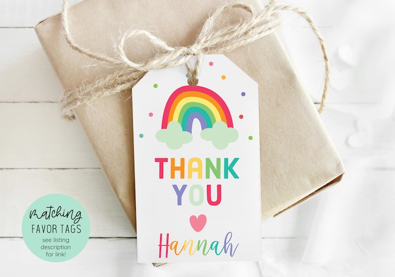 May include: Rainbow-themed thank you tag with the text "Thank You" in rainbow colors and the name "Hannah" in purple. The tag features a colorful rainbow with clouds and confetti.