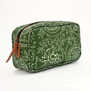 May include: A green paisley patterned zippered pouch with a brown leather zipper pull.