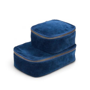 May include: Two blue velvet zippered storage boxes. The smaller box is stacked on top of the larger box.