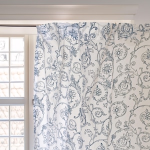 Pode incluir: Cortinas brancas com um padrão floral azul. O padrão apresenta vórtices e folhas intrincados.