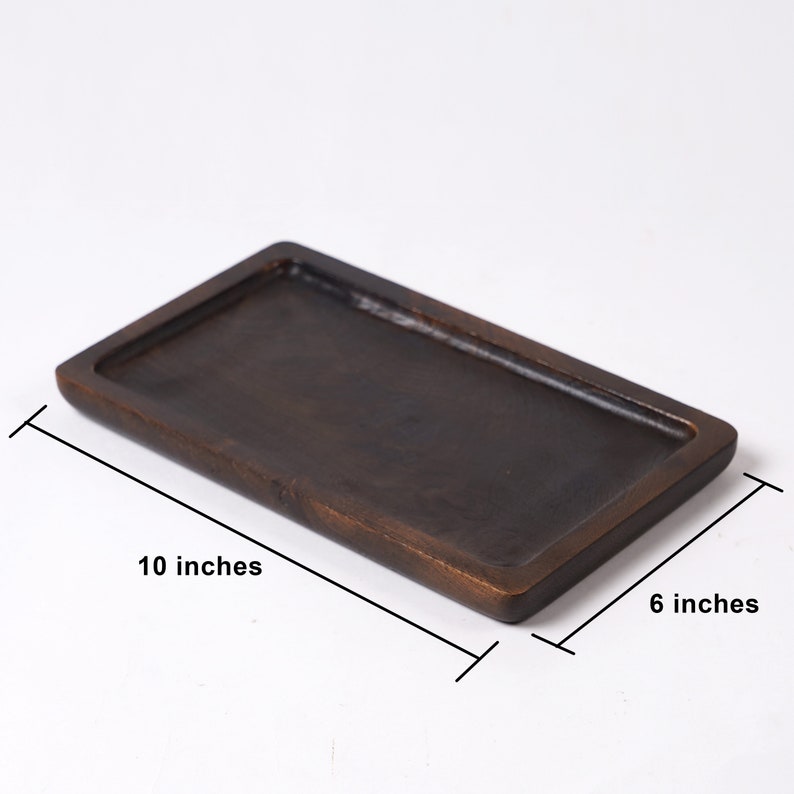 May include: A rectangular wooden tray with a dark brown finish. The tray measures 10 inches long and 6 inches wide.