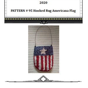 May include: A red, white, and blue hooked rug Americana flag with a white star in the blue field. The flag is hanging from a brown cord and is on a white background. The text "PATTERN # 95 Hooked Rug Americana Flag" is above the image.