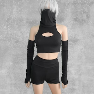 May include: Black crop top with a cut-out detail and matching long fingerless gloves. The top and gloves are made of a stretchy, comfortable fabric.