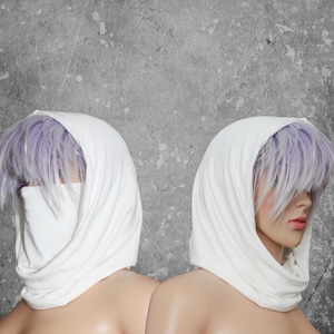 Peut inclure: Deux mannequins portent des &eacute;charpes &agrave; capuche blanches. Les &eacute;charpes sont drap&eacute;es autour de la t&ecirc;te et du cou, avec un couvre-visage. Le fond est un mur gris textur&eacute;.