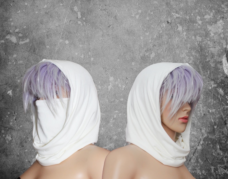 Peut inclure: Deux mannequins portent des &eacute;charpes &agrave; capuche blanches. Les &eacute;charpes sont drap&eacute;es autour de la t&ecirc;te et du cou, avec un couvre-visage. Le fond est un mur gris textur&eacute;.