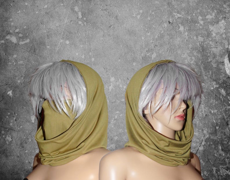 Peut inclure: Deux mannequins portant des &eacute;charpes &agrave; capuche vert olive. Les &eacute;charpes sont drap&eacute;es autour du cou et du visage, avec la capuche relev&eacute;e. Les mannequins ont la peau p&acirc;le et des perruques grises. Le fond est un mur gris textur&eacute;.