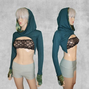 May include: A teal hooded crop top with long sleeves and a tie-dye pattern on the inside of the hood. The top is shown on a model wearing a black lace bralette and light grey shorts.