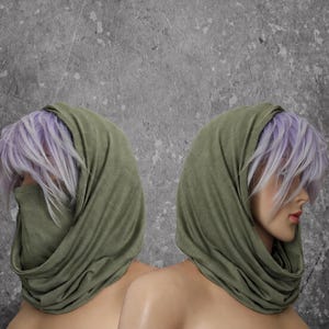 Peut inclure: Deux mannequins avec des perruques lavande et des couvre-chefs vert olive. Le tissu est drap&eacute; autour du cou et du visage. Le fond est gris mouchet&eacute;.