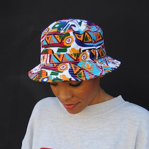 Model wearing vintage FILA sweatshirt and white bucket hat with colorful 90s abstract design.