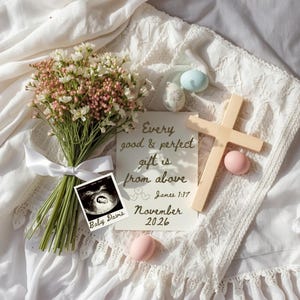 May include: A bouquet of white and pink flowers tied with a white ribbon, an ultrasound image, a wooden cross, and pastel-colored eggs are arranged on a white, textured surface. A card with the text "Every good & perfect gift is from above" is also present. The text "November 2026" is also visible.