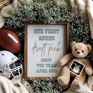 Puede incluir: Un arreglo decorativo con un balón de fútbol americano marrón, un casco blanco y un oso de peluche. Un letrero enmarcado dice "OUR FIRST ROUND draft pick JOINS THE TEAM APRIL 2026." Una imagen de ultrasonido está adjunta al oso de peluche.
