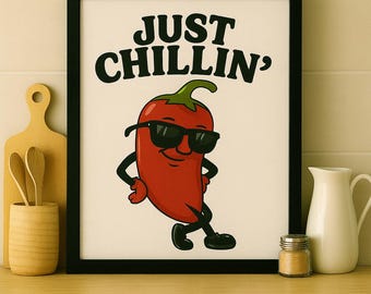 May include: A framed print featuring a red chili pepper wearing sunglasses and striking a relaxed pose. The text "JUST CHILLIN'" is displayed above the pepper. The image is set against a cream background.