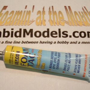 May include: A blue and yellow tube of Beacon Foam Tac adhesive with the text "Powerful Foam Glue" and "Bonds Depron, EPP, EPO, Balsa, Carbon Fiber" printed on the tube. The tube is 1 fluid ounce (33 ml).