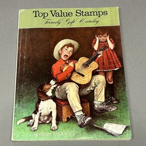 Puede incluir: Una portada vintage del catálogo de regalos para la familia Top Value Stamps con una ilustración de Norman Rockwell de un niño tocando la guitarra, una niña tapándose las orejas y un perro. El texto "Top Value Stamps Family Gift Catalog" está impreso en verde sobre un fondo verde claro.