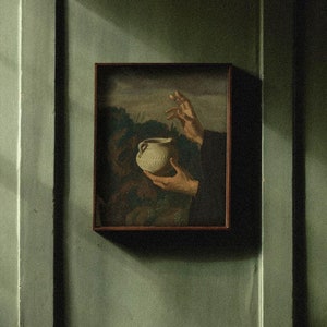 Könnte beinhalten: Ein gerahmtes Gemälde einer Hand, die nach einem weißen Keramik-Krug greift, vor einem grünen Hintergrund.