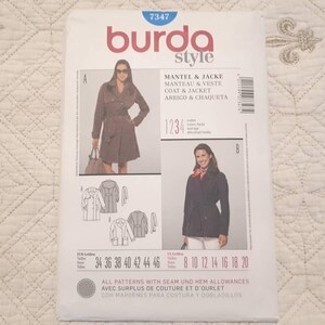 May include: A Burda Style sewing pattern for a coat and jacket. The pattern features images of the finished garments, with sizes listed in both European and US measurements. The cover includes the text "MANTEL & JACKE, MANTEAU & VESTE, COAT & JACKET, ABRIGO & CHAQUETA."