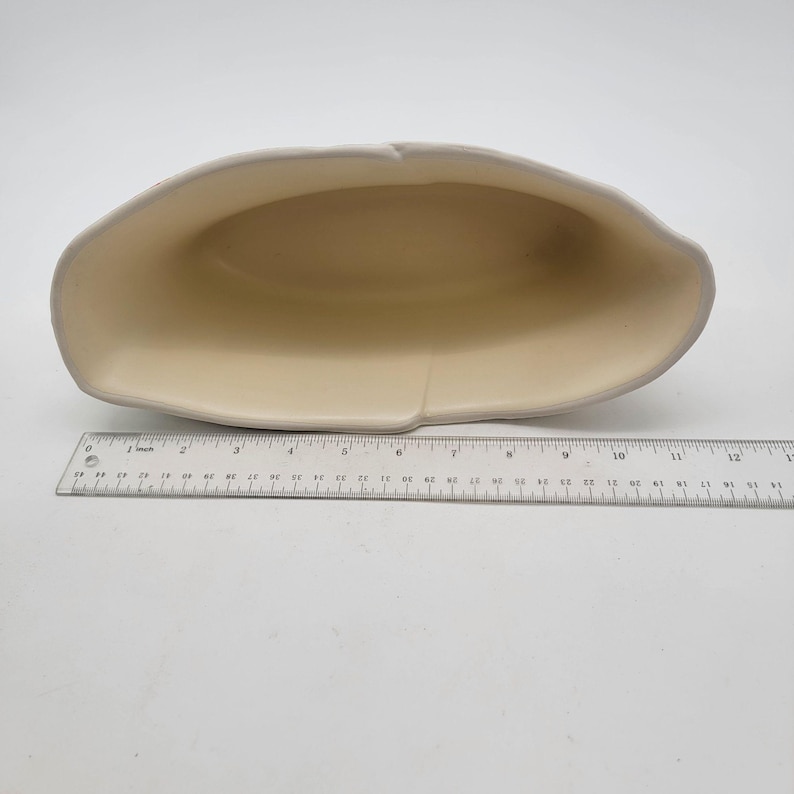 Puede incluir: Una fuente de cer&aacute;mica de color crema con un borde gris claro. La fuente mide aproximadamente 30 cm de largo y tiene una forma ovalada poco profunda. Se coloca una regla junto a la fuente para la escala.