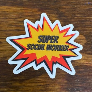 May include: A white sticker with a red and yellow starburst design. The text "SUPER SOCIAL WORKER" is written in black letters inside the starburst.