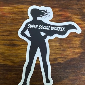 May include: A black silhouette of a woman with long hair blowing in the wind, wearing a cape that says "SUPER SOCIAL WORKER".